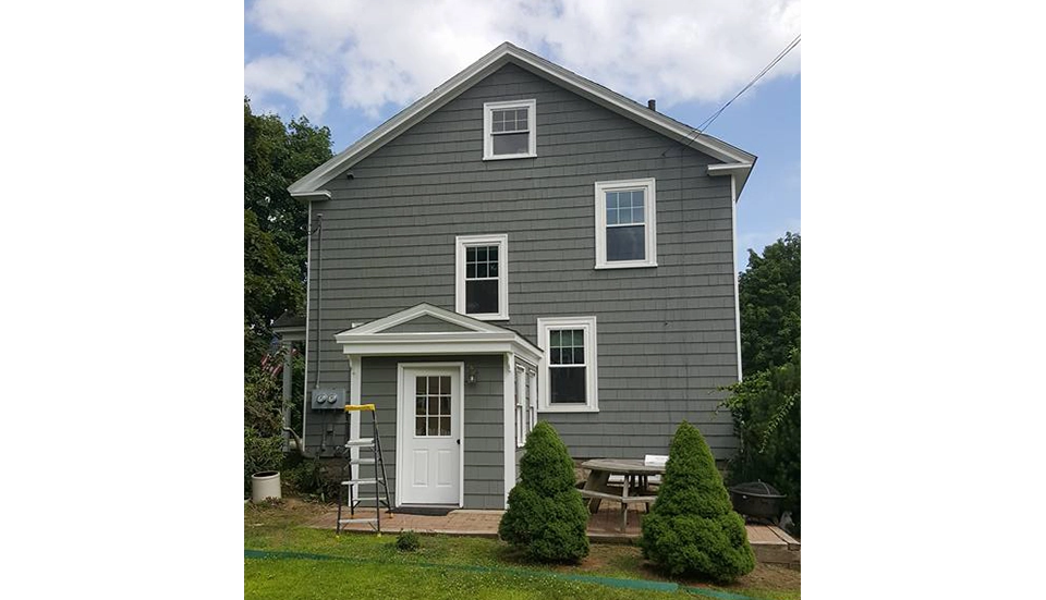 after image of a house exterior with new paint and siding